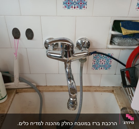ברז מטבח עם צינור גמיש בכיור לבן